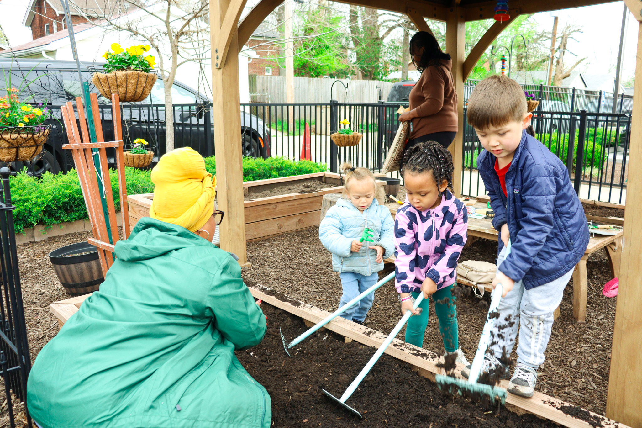Child pulling weeds, raking, or digging in dirt